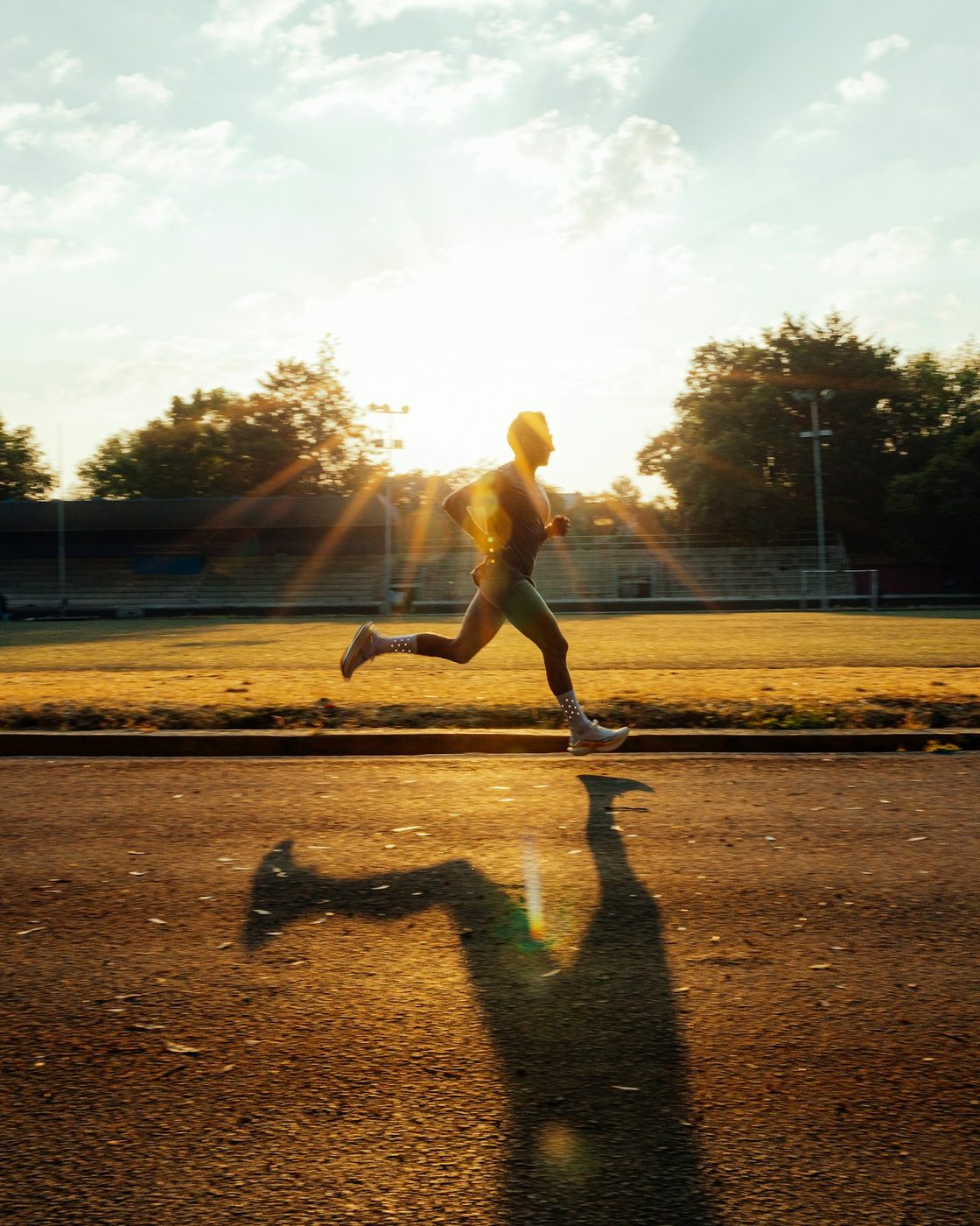 Runner in pista alla luce del sole